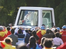  Pope kissing a baby in midst of crowd of volunteers